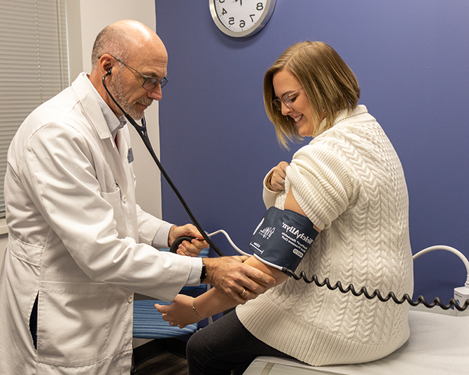 Dr. Heine checking vitals of a staff member patient